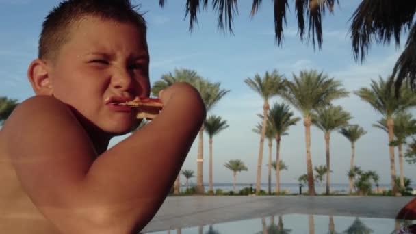 Chico comiendo una rebanada de pizza — Vídeos de Stock