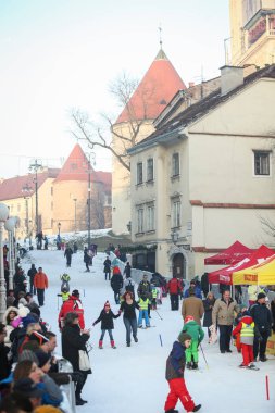 Kids skiing on city ski slope clipart