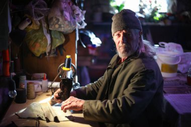 Yaşlı adam evde dikiş