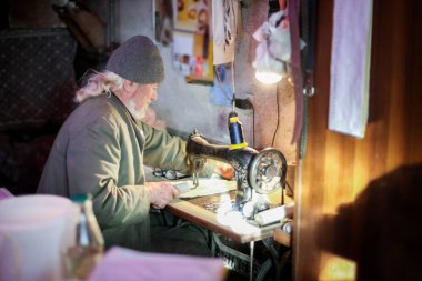 Yaşlı adam dikiş makinesi üzerinde çalışma