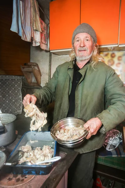 Mann bereitet Schweinefleisch für Mittagessen zu — Stockfoto