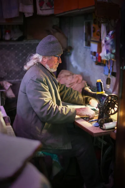 Старший дорослий чоловік зі швейною машиною — стокове фото