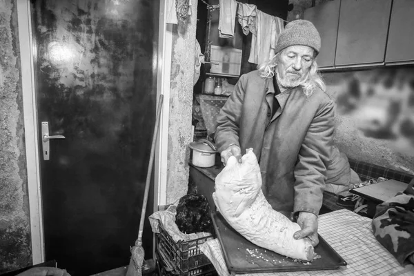 Homem sênior cozinhando porco bw — Fotografia de Stock