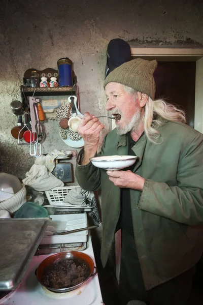 Old man tasting food — Stock Photo, Image