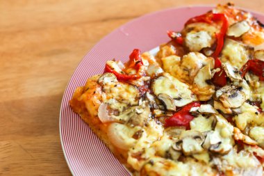 Bir dilim vejetaryen pizzası ve üstünde vejetaryen peyniri..