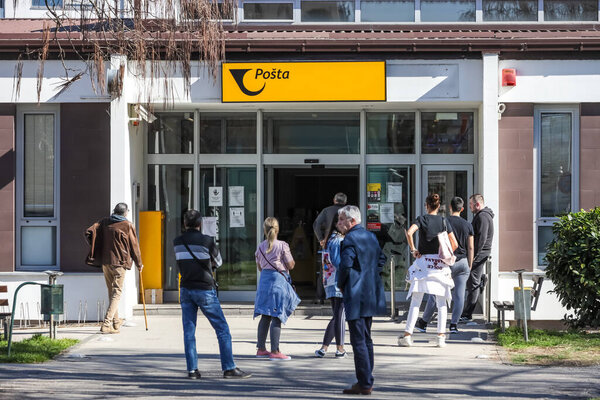 Velika Gorica, Croatia - March 19, 2020 : People on the street waiting in line to get into the post office one by one because of corona virus crisis.