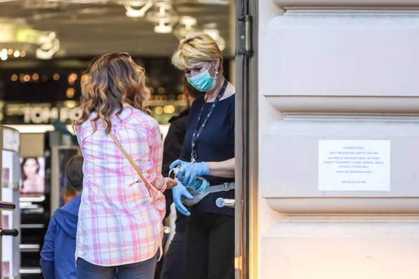 克罗地亚萨格勒布 2020年3月19日 一名店员站在入口 为进入位于潘杰拉尔奇广场的Muller商店的购物者消毒 原因是Corona病毒危机 — 图库照片
