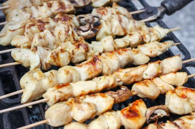 Tavuk eti ve mantar şiş barbeküde ızgara yapıyor..