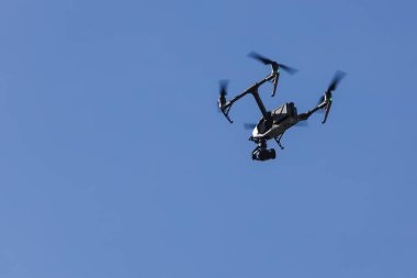 Açık mavi gökyüzünde havada uçan video kaydı için büyük drone.