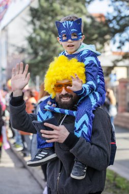 Velika Gorica, Hırvatistan - 22 Şubat 2020: Turopoljski Karnavalı sırasında Velika Gorica ana caddesinde karnaval geçidi gerçekleşti. Seyirciler arasında kostümlü bir baba ve oğul.