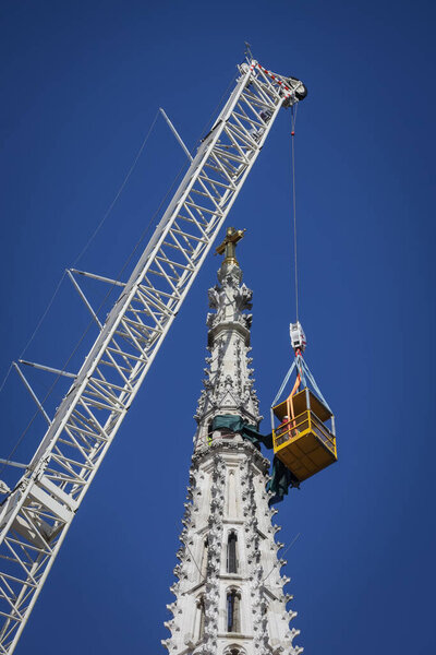 Zagreb, Croatia - April 15, 2020 : Workers with tall cranes are preparing to separate top of the Zagreb Cathedral tower that was damaged by the earthquake of 5.5 on the Richter scale one month ago.