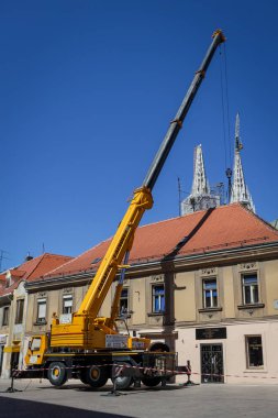 Zagreb, Hırvatistan - 16 Nisan 2020: Bir ay önce Richter ölçeğinde meydana gelen 5,5 şiddetindeki depremde hasar gören çatıları vinçle tamir eden işçiler.