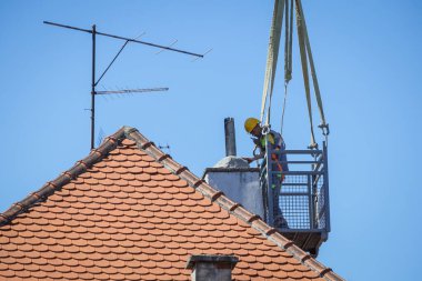 Zagreb, Hırvatistan - 16 Nisan 2020: Bir ay önce Richter ölçeğinde meydana gelen 5,5 şiddetindeki depremde hasar gören çatıları vinçle tamir eden işçiler.