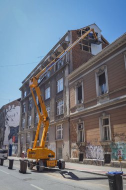 Zagreb, Hırvatistan - 16 Nisan 2020: Bir ay önce Richter ölçeğinde meydana gelen 5,5 şiddetindeki depremde hasar gören çatıları vinçle tamir eden işçiler.