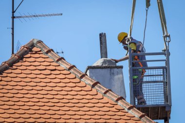 Zagreb, Hırvatistan - 16 Nisan 2020: Bir ay önce Richter ölçeğinde meydana gelen 5,5 şiddetindeki depremde hasar gören çatıları vinçle tamir eden işçiler.