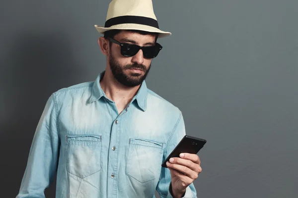 Unga hipster skäggig man bär mössa - grå bakgrund — Stockfoto