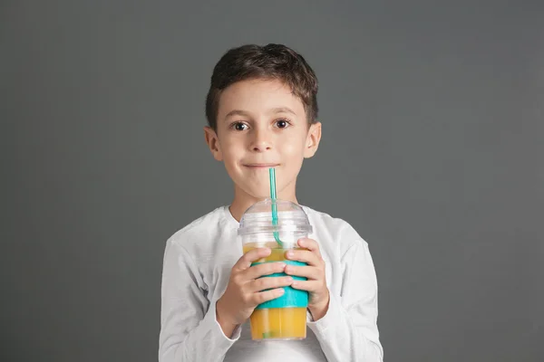 Little funny boy drinking a fresh cola juice through a straw — Stock Photo, Image
