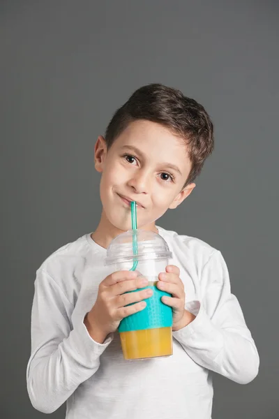 Little funny boy drinking a fresh cola juice through a straw — Stock Photo, Image