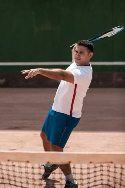 Tenis kortunda yakışıklı genç adam. Tenis oynuyor dostum. Adam vurma tenis topu