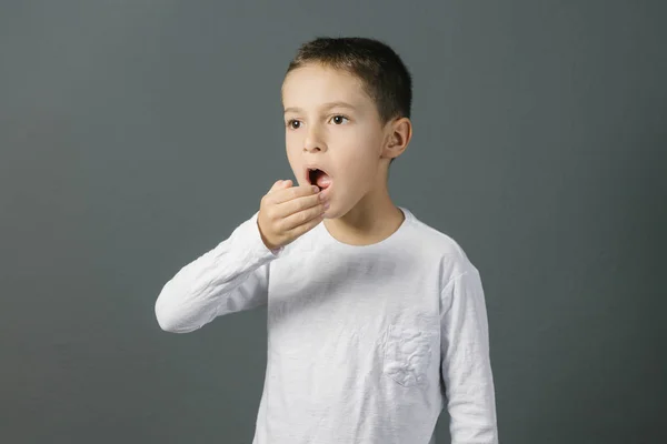 Bad breath. Halitosis concept. Child checking his breath with his hand. Stock Photo