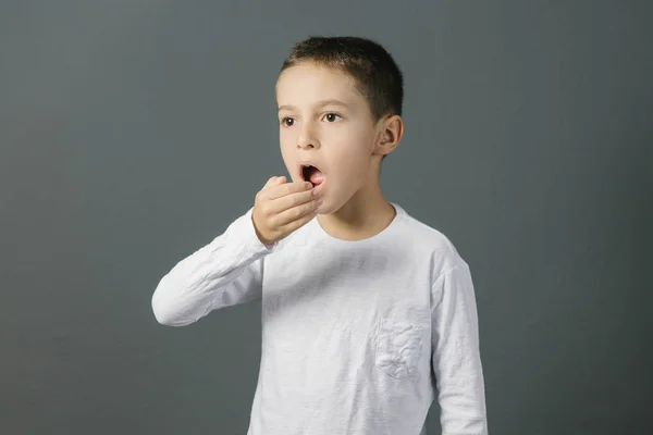 Alito cattivo. Concetto di alitosi. Bambino che controlla il respiro con la mano . Foto Stock