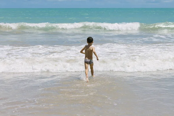 Sześciolatek chłopiec zabawy na tropikalnej plaży w słoneczny dzień — Zdjęcie stockowe