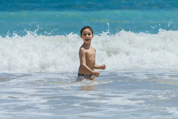 6-jähriger Junge amüsiert sich bei sonnigem Wetter am tropischen Strand — Stockfoto