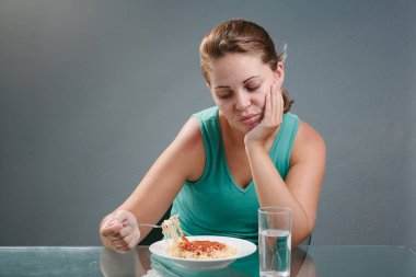 Portrait of woman with no appetite in front of the meal. Concept clipart