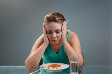 Portrait of woman with no appetite in front of the meal. Concept