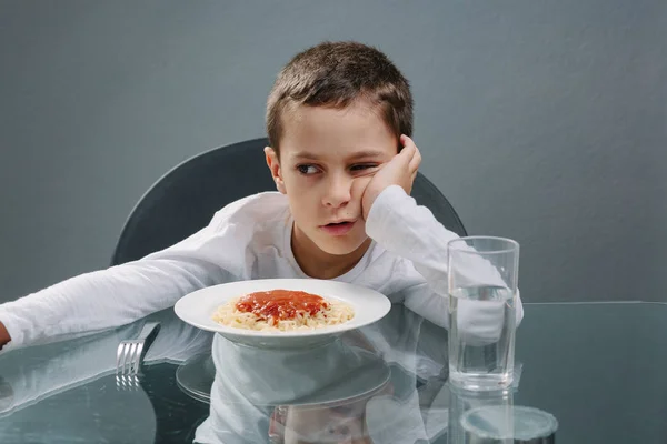 Retrato de un niño sin apetito delante de la comida. Concepto —  Fotos de Stock