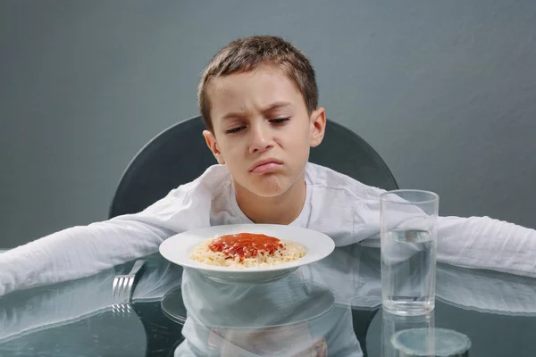 Retrato de un niño sin apetito delante de la comida. Concepto —  Fotos de Stock