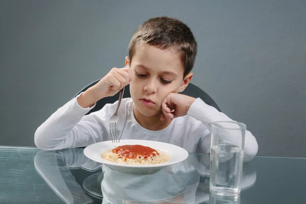 Retrato de un niño sin apetito delante de la comida. Concepto —  Fotos de Stock