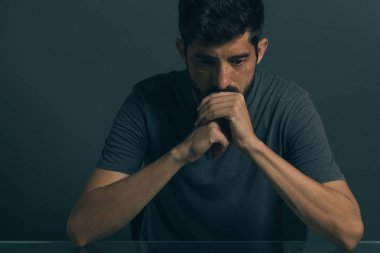 Karanlık odada oturan üzgün adam. Depresyon ve anksiyete bozukluğu