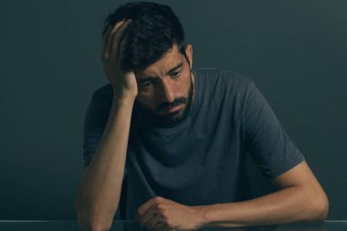 Karanlık odada oturan üzgün adam. Depresyon ve anksiyete bozukluğu