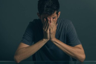 Karanlık odada oturan üzgün adam. Depresyon ve anksiyete bozukluğu