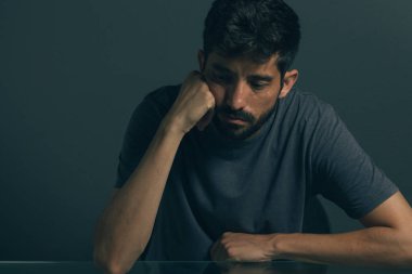 Karanlık odada oturan üzgün adam. Depresyon ve anksiyete bozukluğu