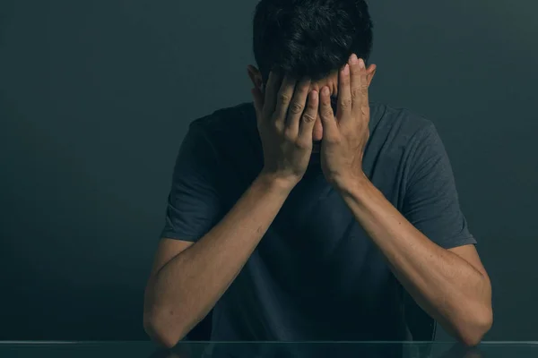 Homem triste sentado no quarto escuro. Conceito de depressão e transtorno de ansiedade — Fotografia de Stock