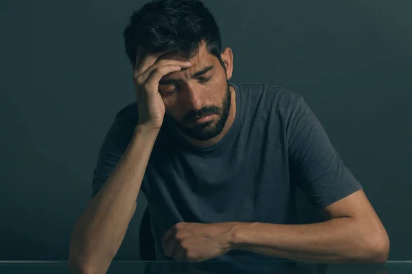 暗い部屋に座っている悲しい男。うつ病と不安障害の概念 — ストック写真