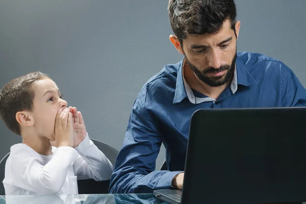 Father on laptop ignoring son while the child tries to catch his attention — Stock Photo, Image