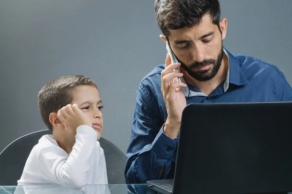 Father on laptop ignoring son while the child tries to catch his attention — Stock Photo, Image