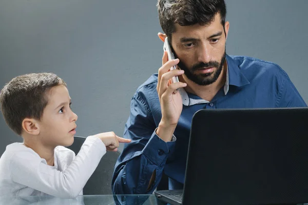 Father on laptop ignoring son while the child tries to catch his attention — Stock Photo, Image