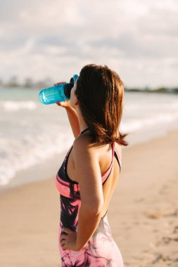 Koşan kadın. Kadın koşucu plajda antrenman yaparken koşuyor.