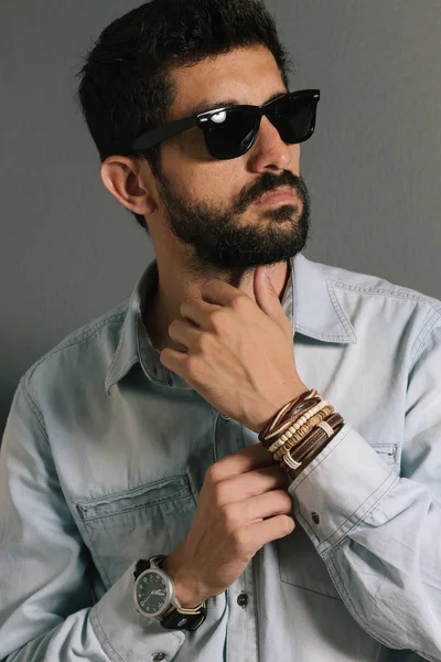 Advertising leather bracelets concept. Portrait of young man wearing leather bracelets and wrist watch.