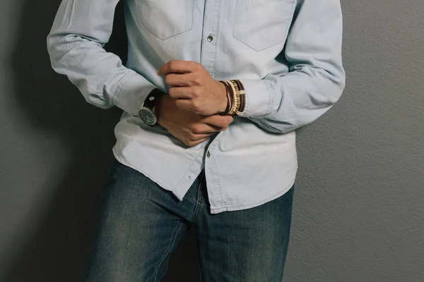 Advertising leather bracelets concept. Portrait of young man wearing leather bracelets and wrist watch.