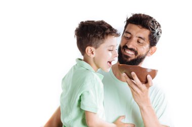 Baba ve oğul Paskalya yortusu yumurta beyaz arka plan üzerinde izole yeme