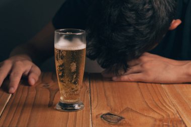 Alkolizm kavramı. Masada bir bardak bira karanlık bir odada ile üzgün adam.