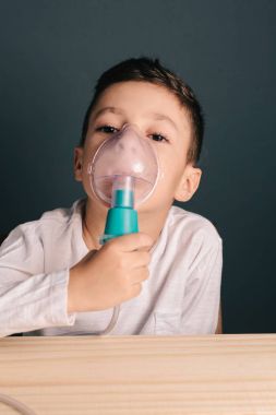 Güzel hasta çocuk enhalasyon tedavisi astım ilacı maskesi tarafından. Görüntü solunum sorunu veya astım ile sevimli bir çocuk. Duman oksijen maskesi ile Nebulizatör görünümünü