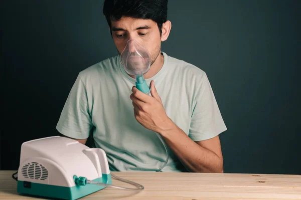 Portrait of young man using inhaler / nebulizer — Stock Photo, Image