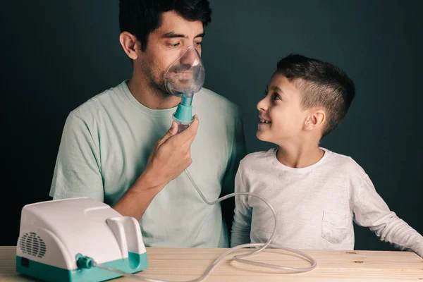 Retrato de padre e hijo usando inhalador / nebulizador doméstico — Foto de Stock