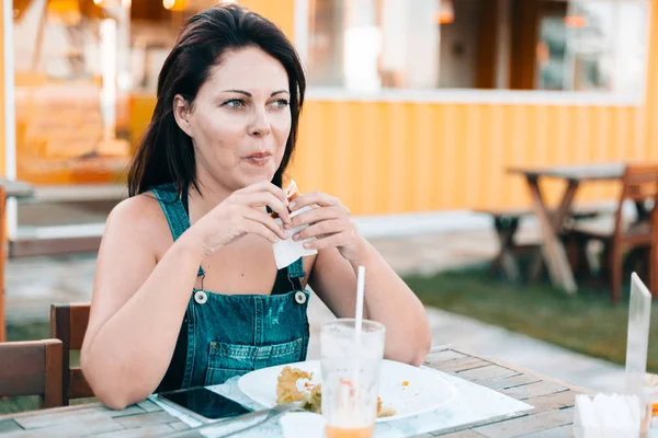 Mujer joven en restaurante al aire libre disfrutando de su comida —  Fotos de Stock